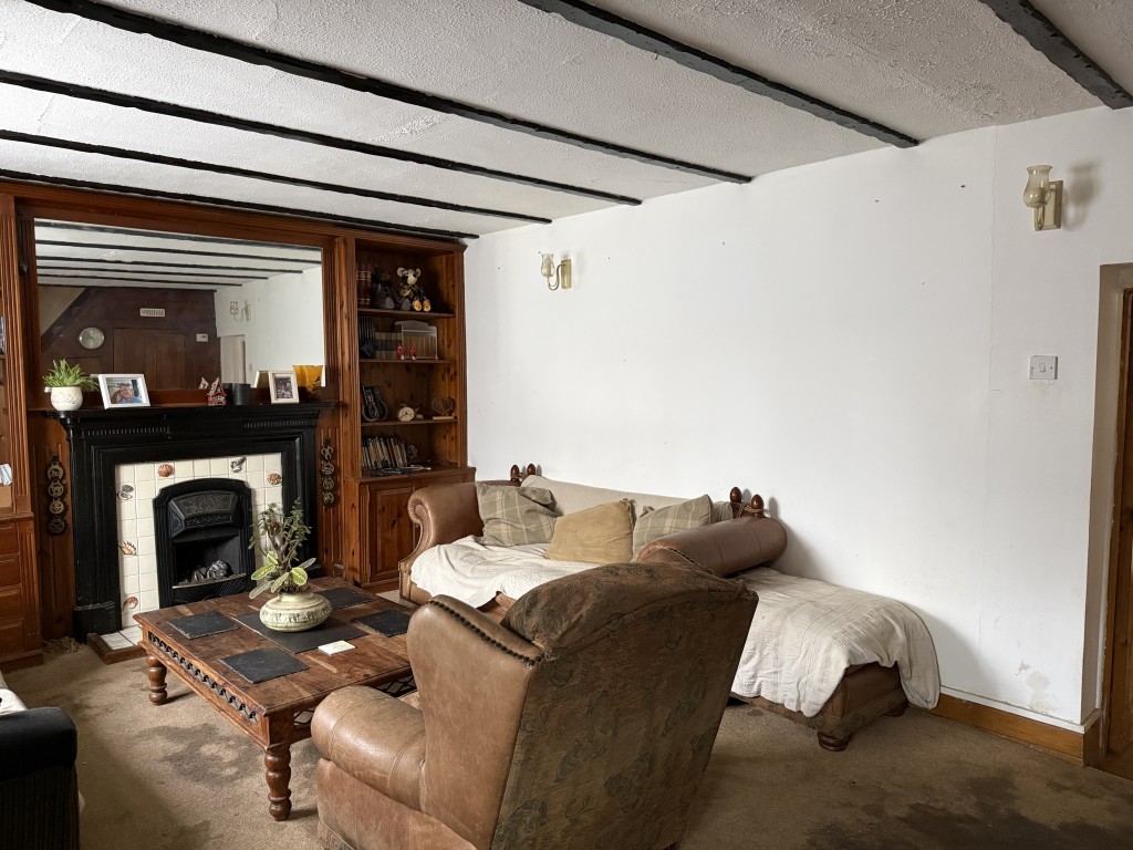 Lot: 58 - FREEHOLD DETACHED COTTAGE FOR INVESTMENT - Living room with fireplace and ceiling beams